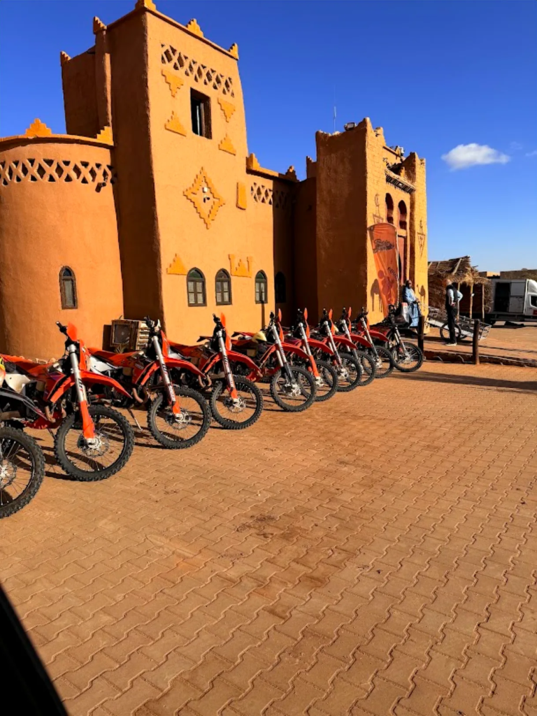 KTM bikes lined up outside a kasbah in Merzouga