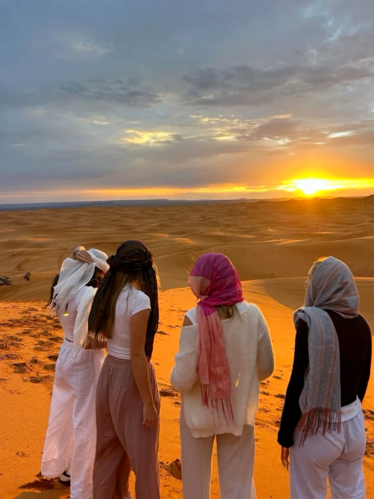 Reisigers kyk na die Sahara-sonsondergang